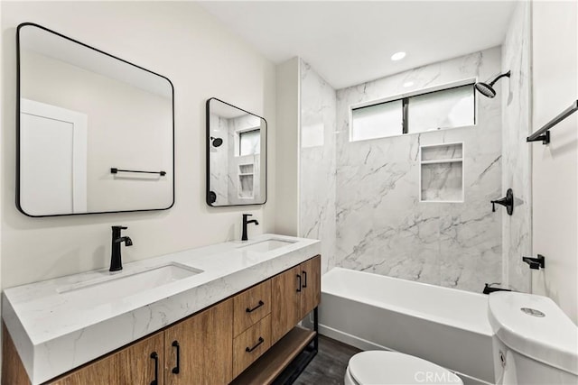 full bathroom with toilet, tiled shower / bath combo, wood-type flooring, and vanity