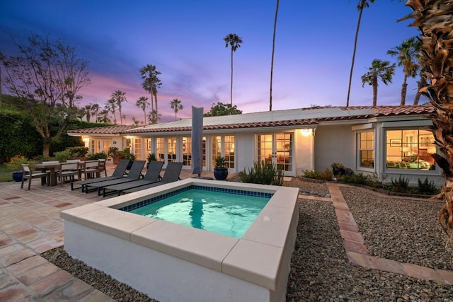 pool at dusk featuring a patio area