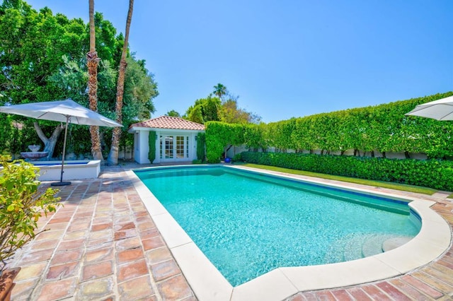 view of pool featuring an outbuilding and a patio