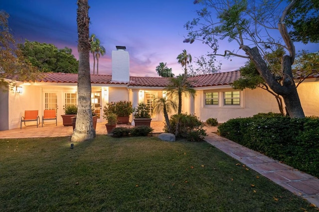 mediterranean / spanish house featuring a yard and a patio