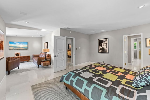 bedroom with light tile patterned floors and ensuite bath