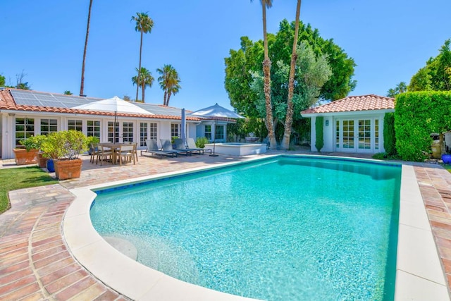 view of swimming pool featuring french doors, a patio, and an outdoor structure