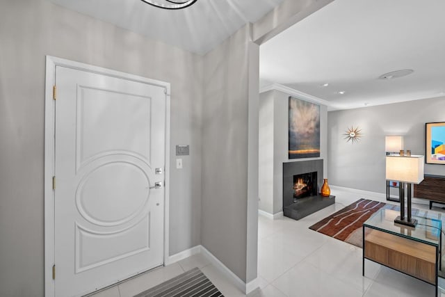 tiled foyer entrance featuring crown molding