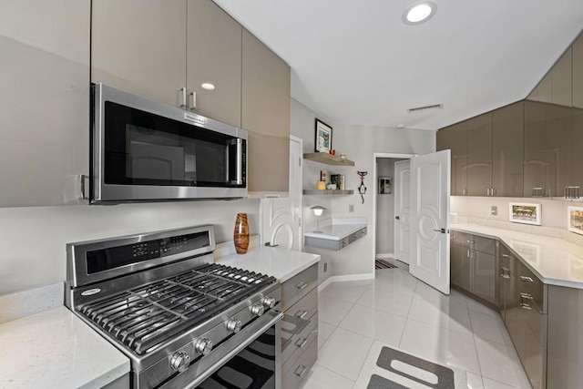 kitchen featuring appliances with stainless steel finishes, light tile patterned flooring, and gray cabinets