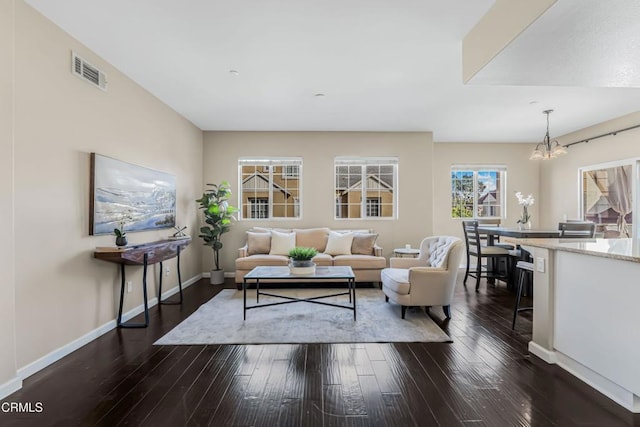 living room featuring a notable chandelier and dark hardwood / wood-style flooring