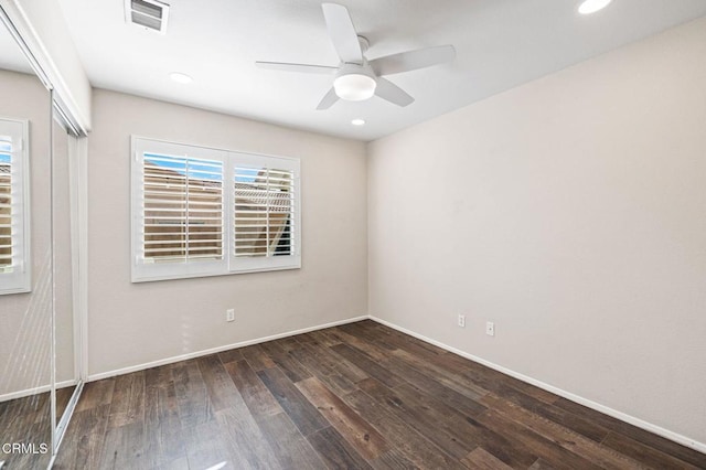 spare room with ceiling fan and dark wood-type flooring