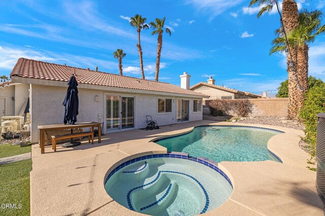 view of swimming pool featuring an in ground hot tub and a patio