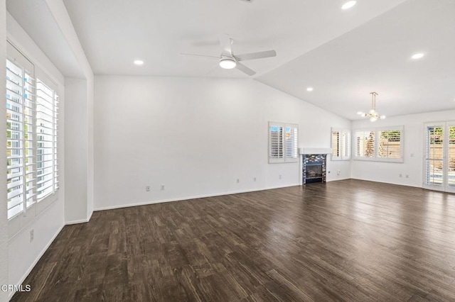 unfurnished living room with lofted ceiling, ceiling fan with notable chandelier, and dark hardwood / wood-style floors