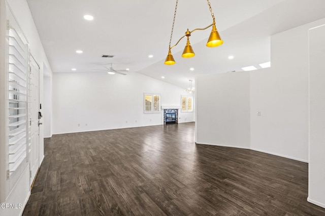 unfurnished living room with ceiling fan, a wealth of natural light, dark hardwood / wood-style flooring, and vaulted ceiling