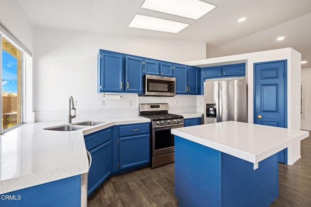 kitchen featuring stainless steel appliances, lofted ceiling, blue cabinetry, and sink