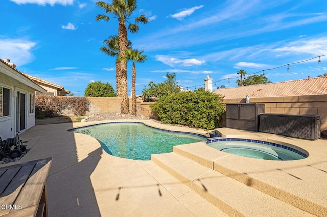 view of swimming pool with a patio and an in ground hot tub