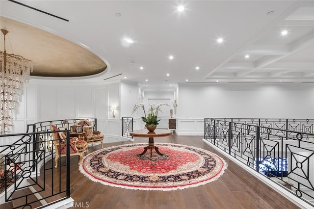 corridor with dark hardwood / wood-style floors, beam ceiling, and coffered ceiling