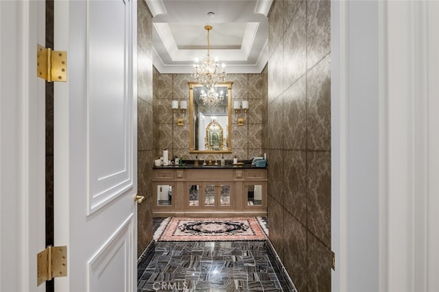 hall featuring an inviting chandelier and a tray ceiling