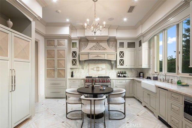 kitchen with decorative light fixtures, backsplash, premium range hood, sink, and range with two ovens