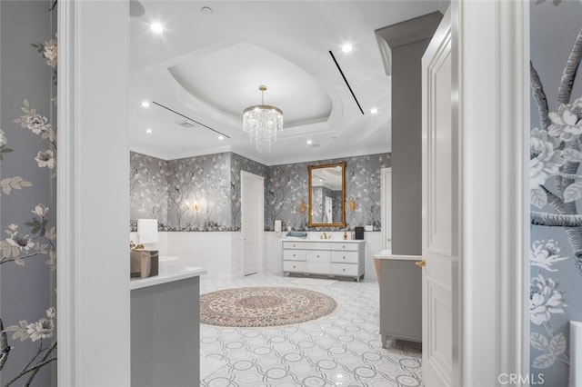 bathroom featuring crown molding, vanity, a notable chandelier, and a tray ceiling