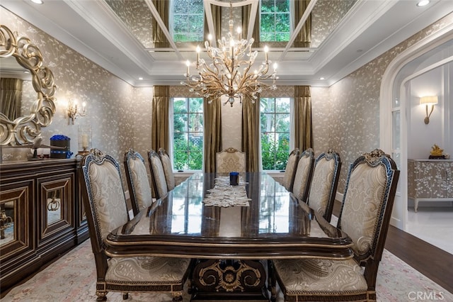 dining space with hardwood / wood-style flooring, a raised ceiling, crown molding, and an inviting chandelier