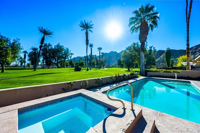 view of swimming pool with a mountain view and a lawn