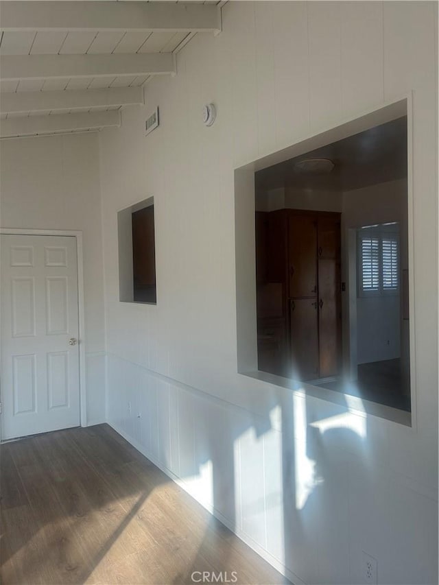 spare room featuring wooden ceiling, wood-type flooring, and vaulted ceiling with beams