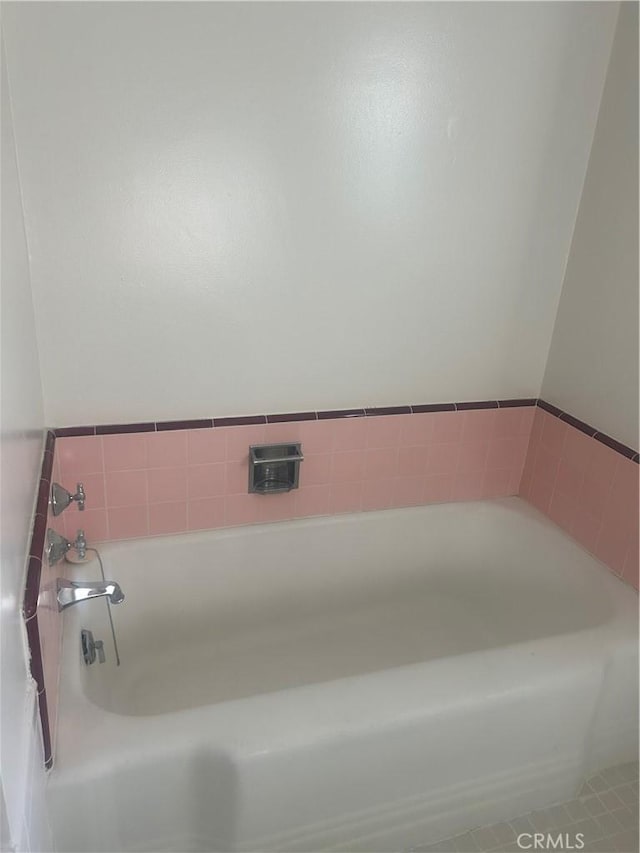 bathroom with tile patterned floors and a washtub