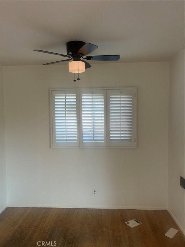 empty room with ceiling fan and dark hardwood / wood-style flooring