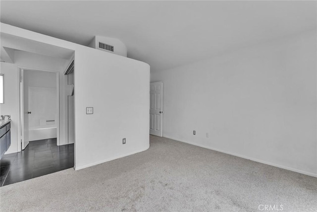 carpeted empty room featuring vaulted ceiling