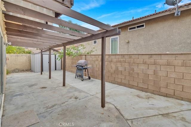 view of patio with a pergola, area for grilling, and a storage unit