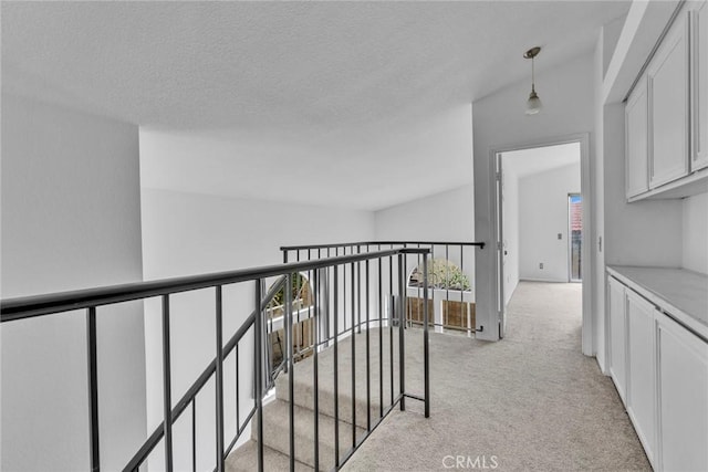 hallway featuring light colored carpet and vaulted ceiling