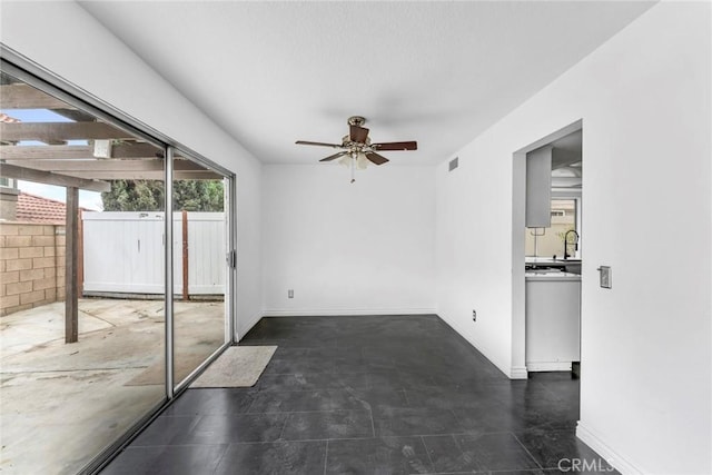 unfurnished room with ceiling fan and sink