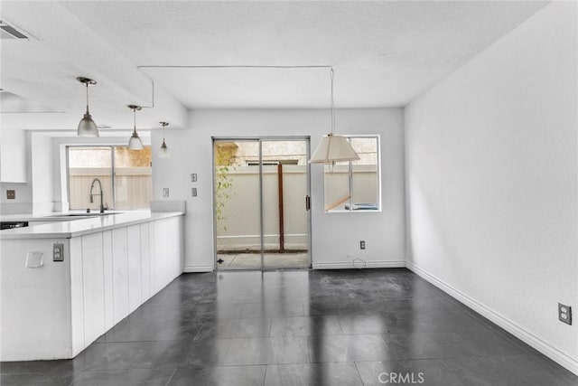 kitchen featuring white cabinetry, pendant lighting, and sink