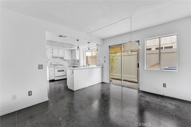 kitchen featuring decorative light fixtures, kitchen peninsula, sink, white cabinets, and white range oven