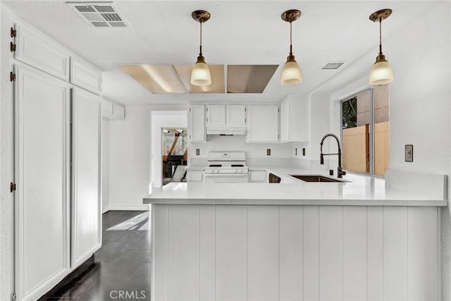 kitchen with decorative light fixtures, white cabinetry, gas range gas stove, and kitchen peninsula