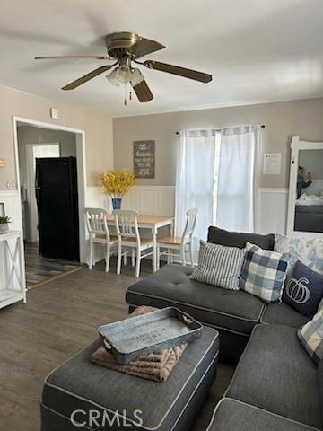 living room with ceiling fan and dark wood-type flooring