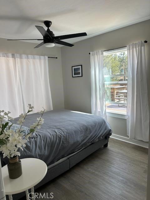 bedroom with ceiling fan and dark wood-type flooring