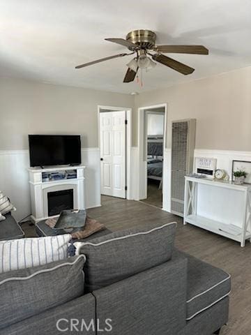 living room with dark wood-type flooring and ceiling fan