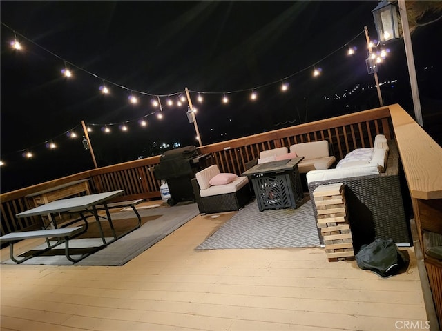 deck at twilight featuring an outdoor living space with a fire pit