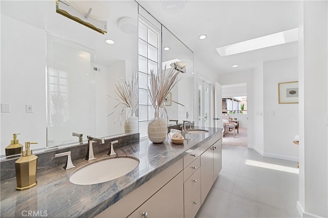 bathroom featuring vanity, a skylight, and tile patterned floors