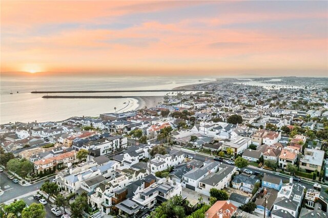 aerial view at dusk featuring a water view