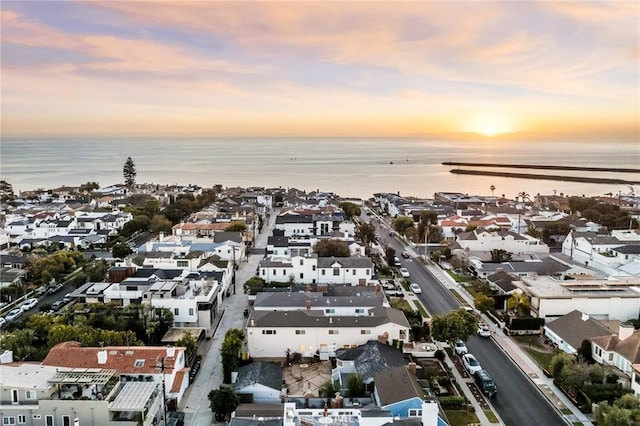 aerial view at dusk featuring a water view