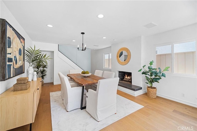 dining area featuring an inviting chandelier and light hardwood / wood-style floors