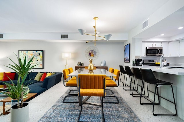 dining area with a notable chandelier and sink