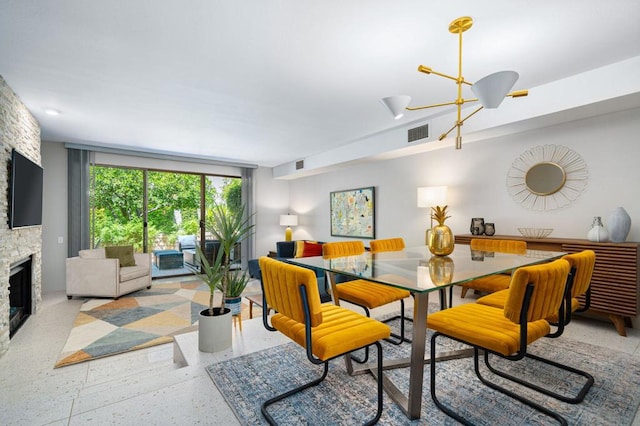 dining area featuring a chandelier and a fireplace