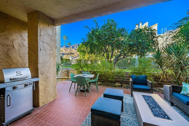 view of patio featuring grilling area, a mountain view, and an outdoor fire pit