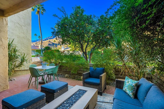 view of patio with a mountain view and an outdoor living space with a fire pit