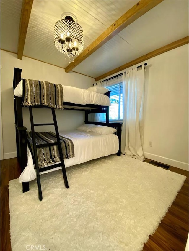 unfurnished bedroom featuring dark hardwood / wood-style flooring, beamed ceiling, and a notable chandelier