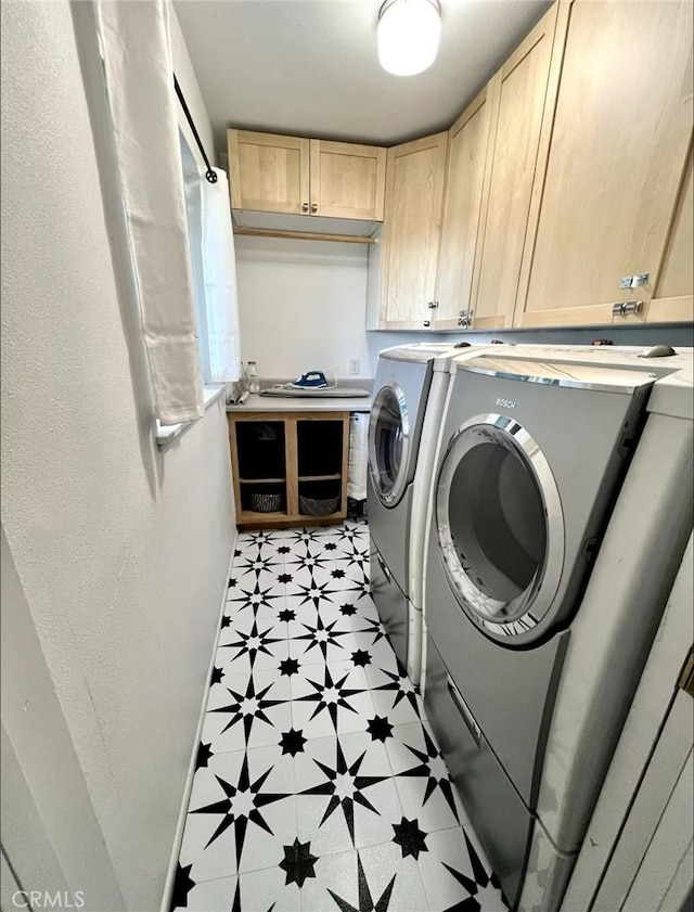 washroom with cabinets and washer and dryer