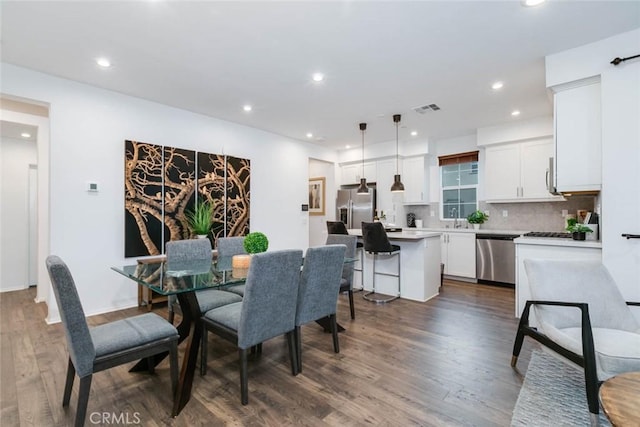 dining space with dark hardwood / wood-style floors and sink