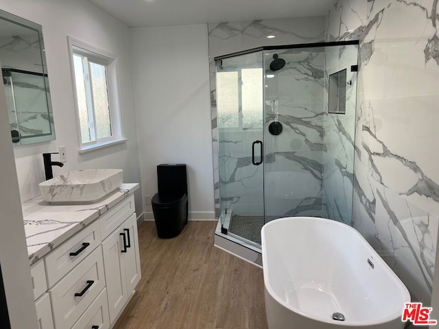 full bathroom with toilet, vanity, wood-type flooring, and shower with separate bathtub