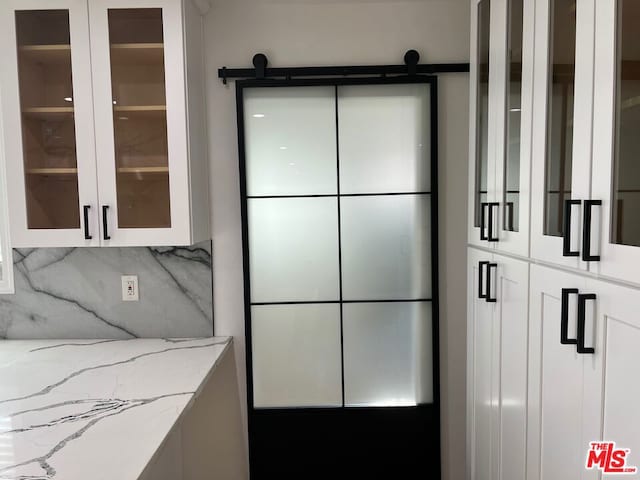 interior space featuring tasteful backsplash and a barn door