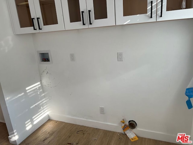 washroom with cabinets, hardwood / wood-style flooring, and hookup for a washing machine