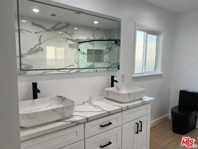 bathroom featuring vanity, hardwood / wood-style floors, and a shower with door